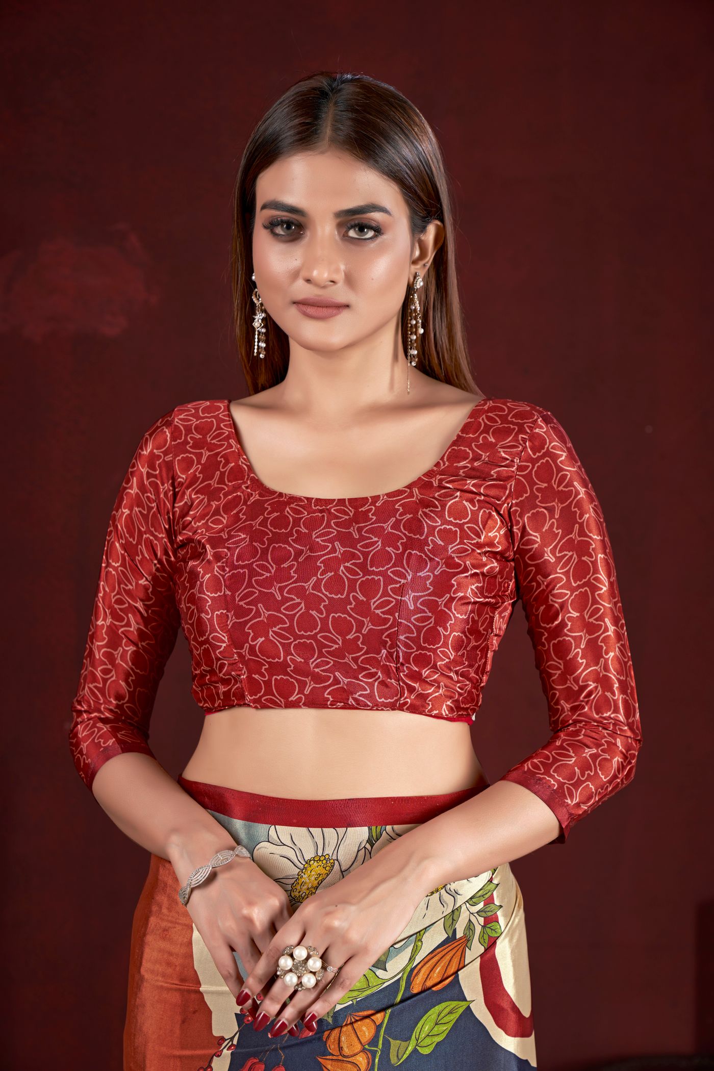 Woman wearing a scoop-neck embroidered blouse with a patterned saree.