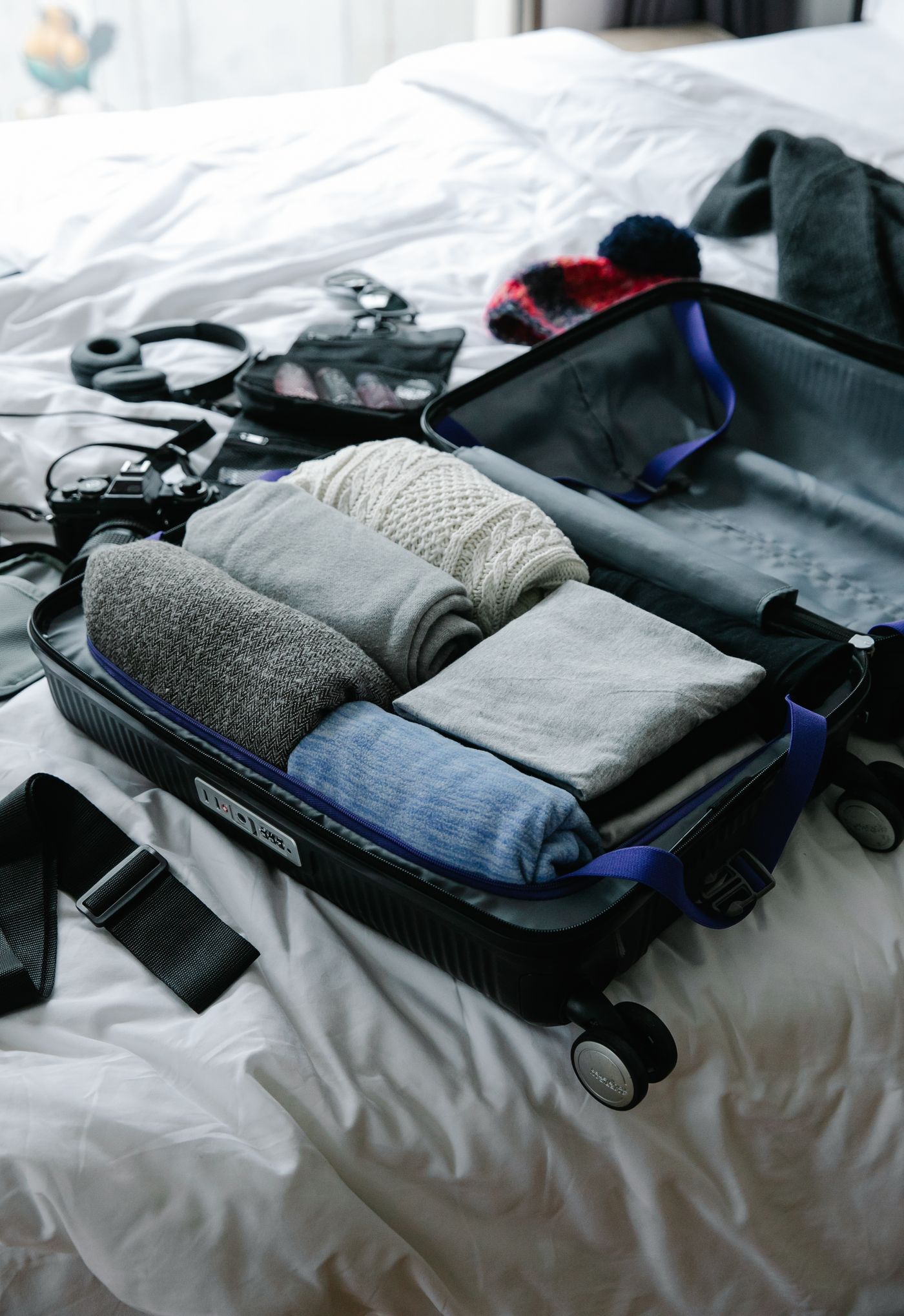 Open suitcase containing neatly folded clothing and travel accessories.