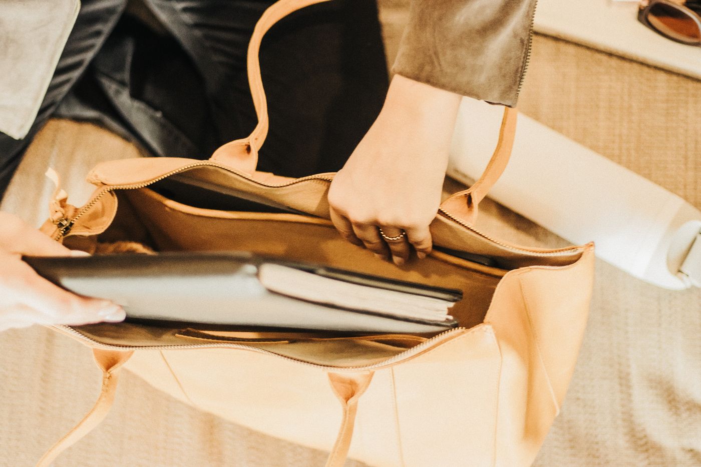 Open leather tote holding a laptop and notebook.