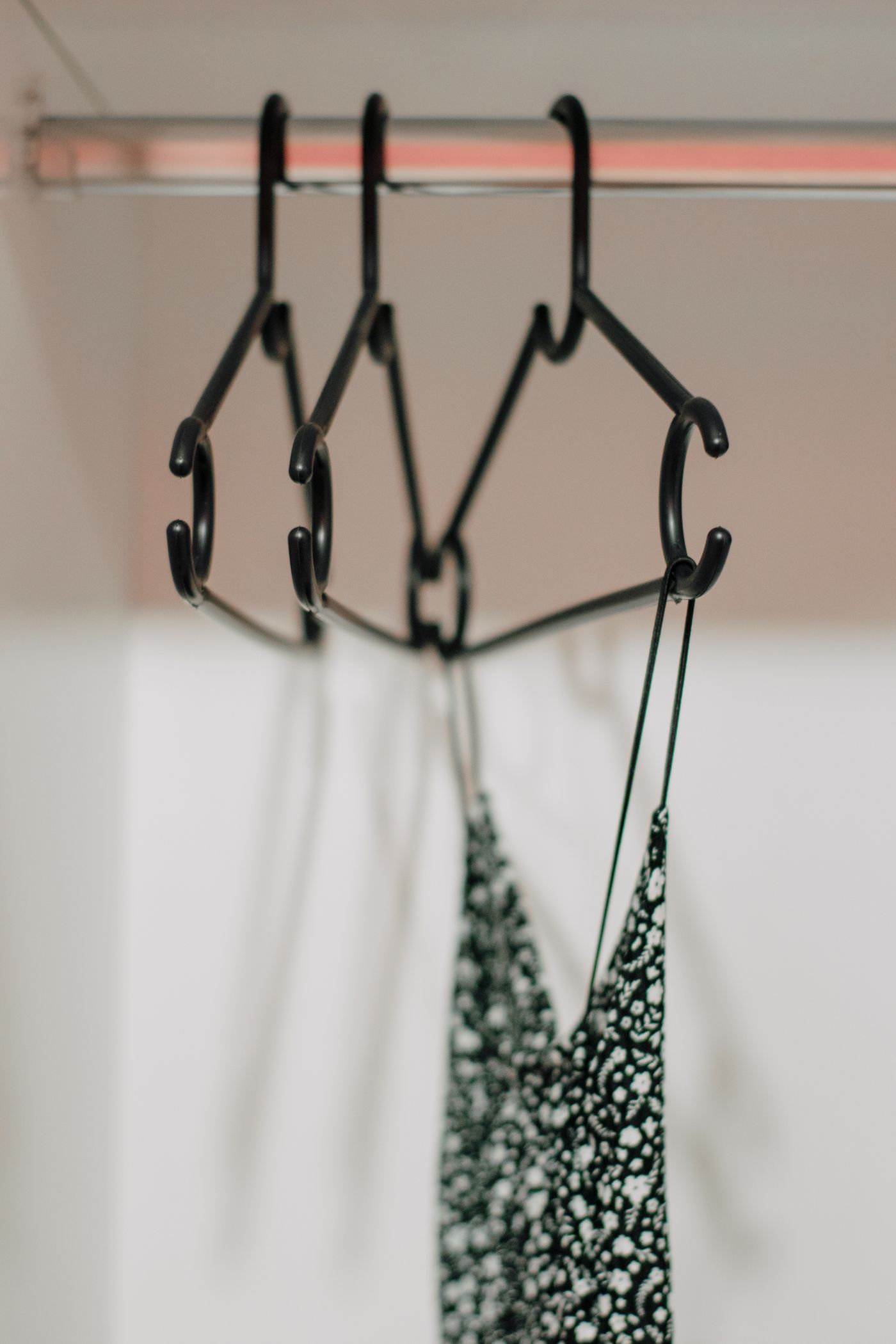 Thin-strapped delicate garments held on hangers.